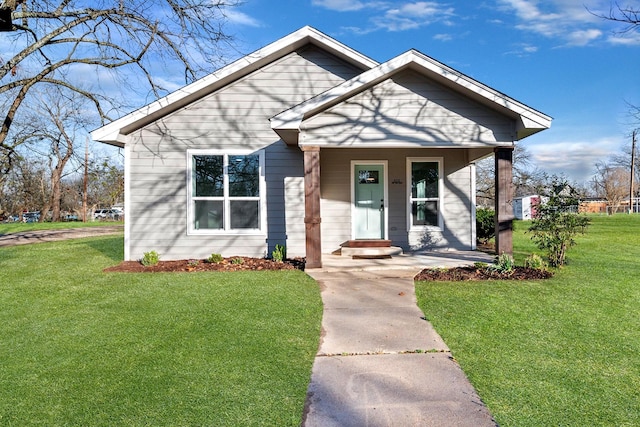 bungalow-style house with a front yard and covered porch