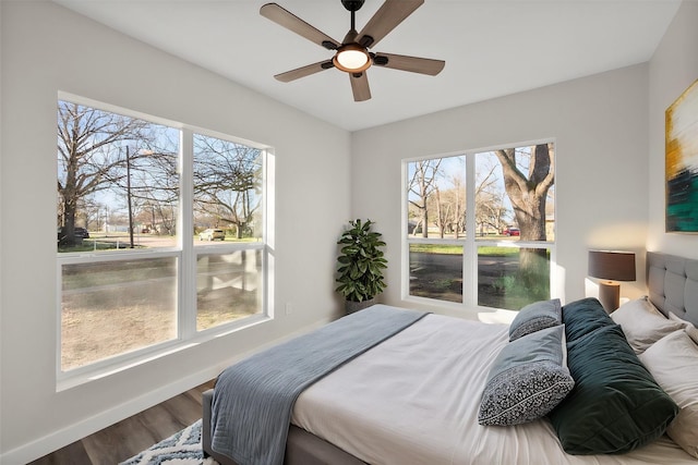 bedroom with ceiling fan, baseboards, and wood finished floors