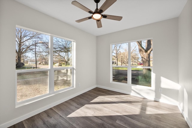 spare room with a ceiling fan, baseboards, and dark wood-style flooring