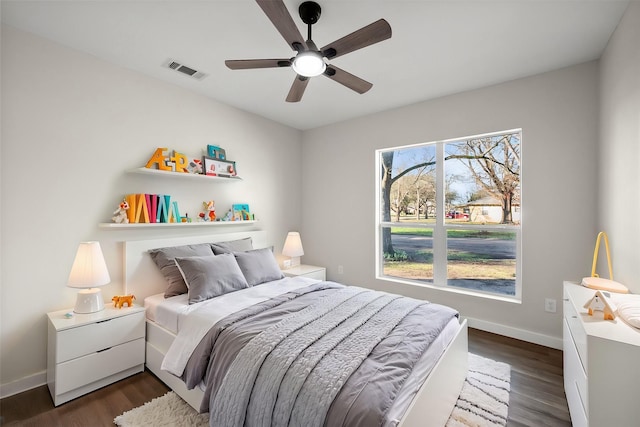 bedroom featuring dark wood finished floors, visible vents, a ceiling fan, and baseboards