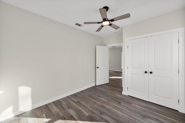 unfurnished bedroom with visible vents, dark wood-style floors, a closet, baseboards, and ceiling fan