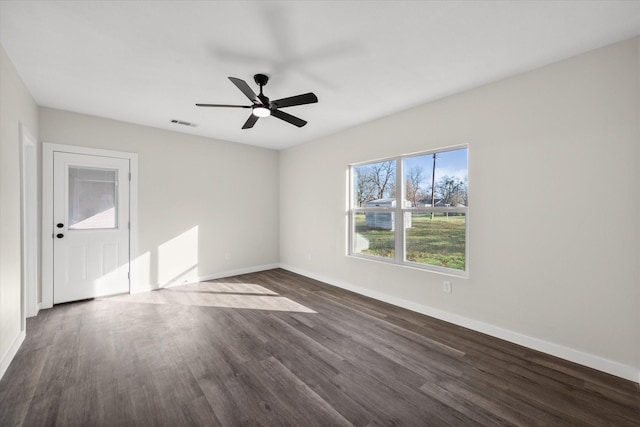 unfurnished room with dark wood-type flooring, visible vents, baseboards, and ceiling fan