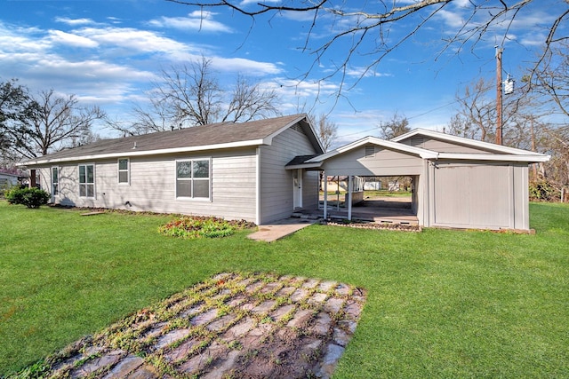 back of property with a lawn and a detached carport