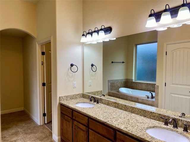 bathroom featuring a bath, tile patterned flooring, double vanity, and a sink