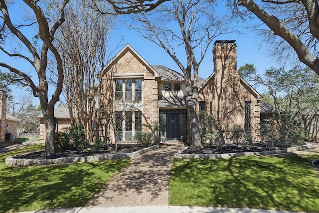 english style home featuring a front yard