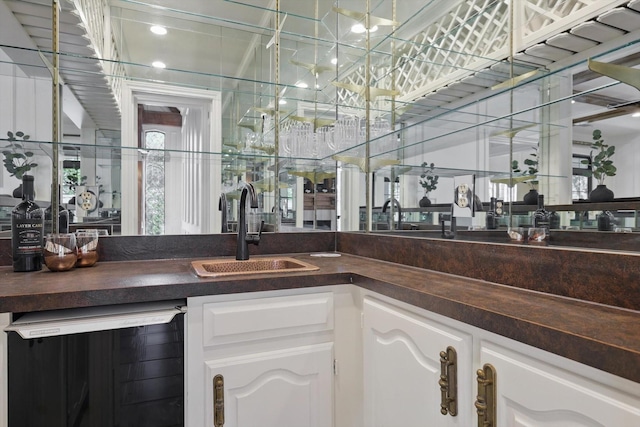 bar with a sink, wet bar, and beverage cooler