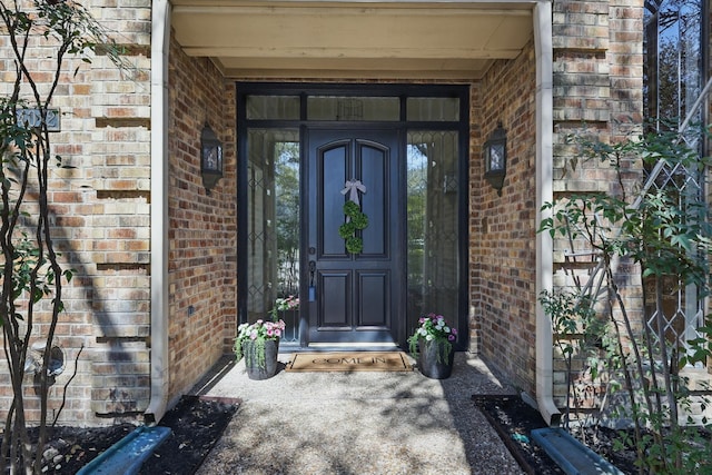 view of exterior entry with brick siding