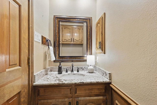 bathroom with vanity and a textured wall