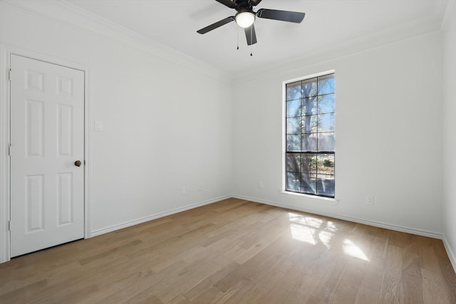 empty room with light wood-type flooring, baseboards, a ceiling fan, and crown molding