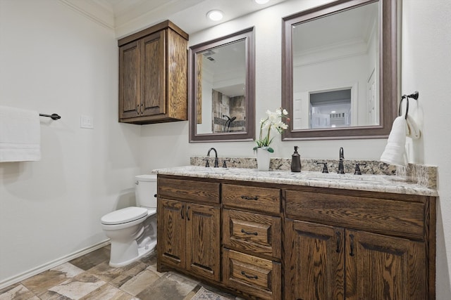 bathroom with a sink, baseboards, toilet, and double vanity