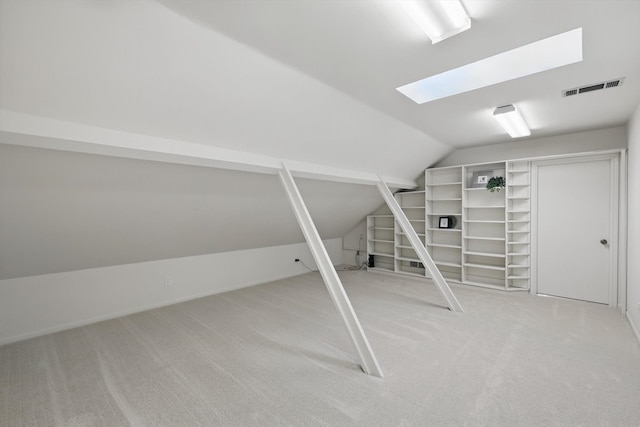 additional living space with lofted ceiling with skylight, visible vents, and light carpet