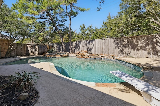 view of swimming pool with a diving board, a fenced in pool, a patio, and a fenced backyard