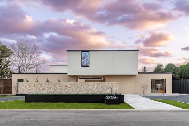 modern home featuring concrete driveway, fence, and stucco siding