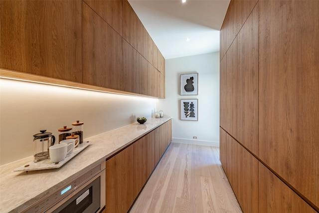 bar featuring baseboards and light wood finished floors