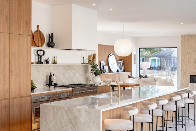 kitchen featuring tasteful backsplash, a breakfast bar, appliances with stainless steel finishes, modern cabinets, and a sink