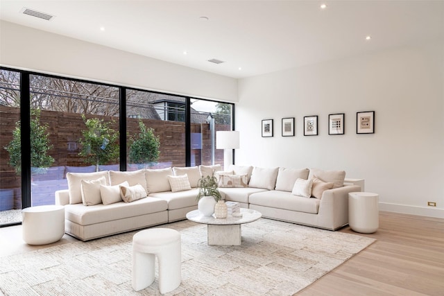 living room with recessed lighting, wood finished floors, visible vents, and baseboards