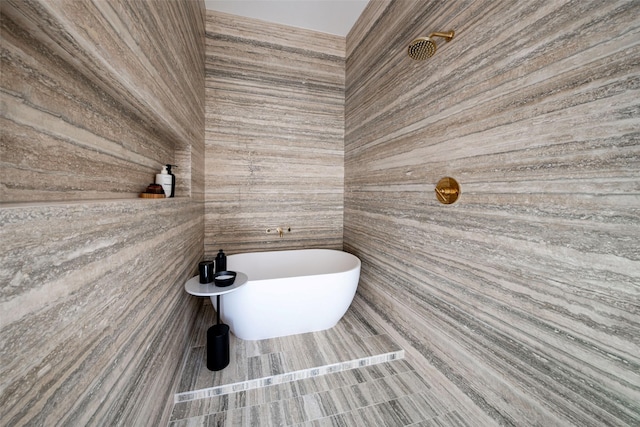 full bath with a soaking tub and tiled shower