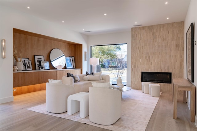 living room with recessed lighting, a fireplace, visible vents, and light wood-type flooring