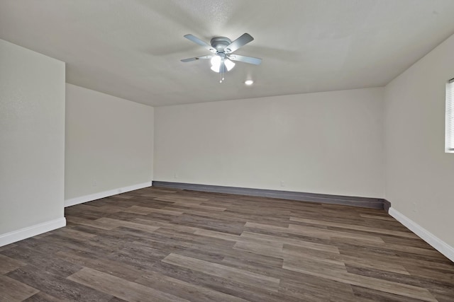 unfurnished room with a ceiling fan, dark wood-style floors, and baseboards