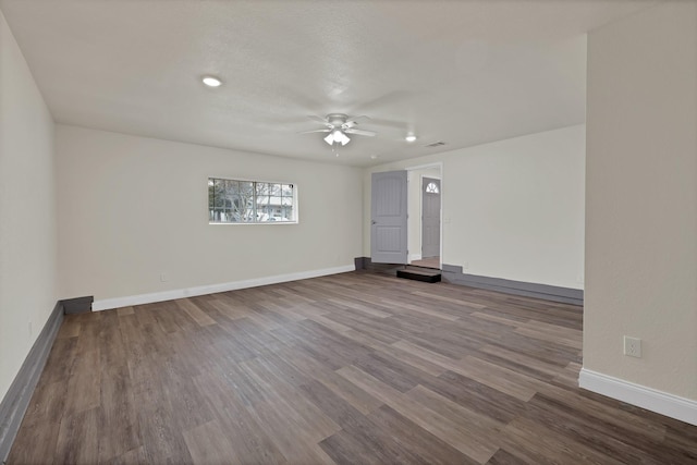 spare room with visible vents, a ceiling fan, baseboards, and wood finished floors