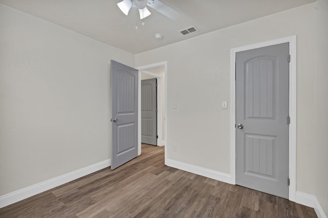 unfurnished bedroom with visible vents, baseboards, and wood finished floors