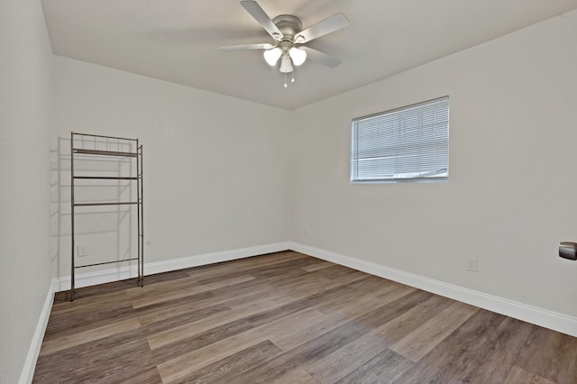 unfurnished room featuring baseboards, wood finished floors, and a ceiling fan