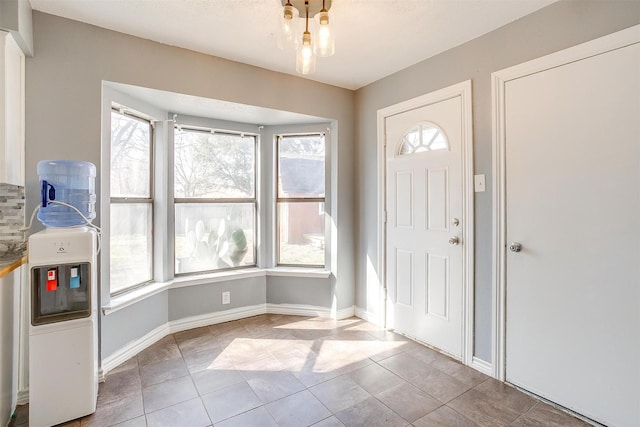 foyer with light tile patterned floors and baseboards