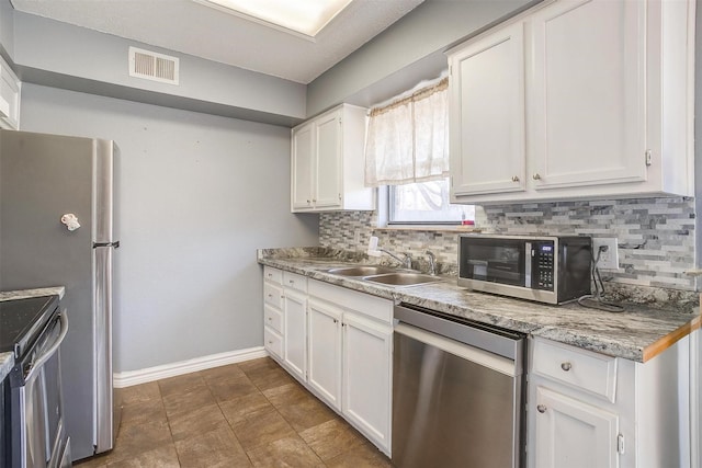 kitchen featuring tasteful backsplash, visible vents, appliances with stainless steel finishes, and a sink