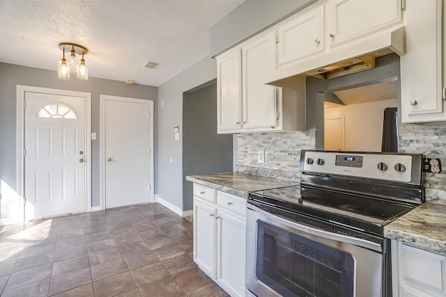 kitchen with visible vents, stainless steel electric range, white cabinets, decorative backsplash, and baseboards