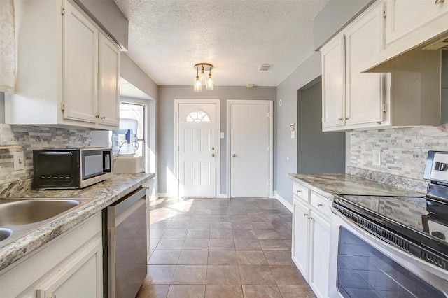 kitchen with visible vents, white cabinetry, stainless steel appliances, and light countertops