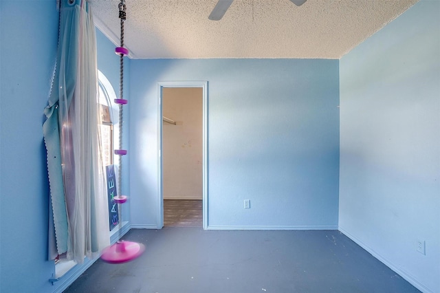 unfurnished room featuring baseboards, a textured ceiling, ceiling fan, and finished concrete flooring