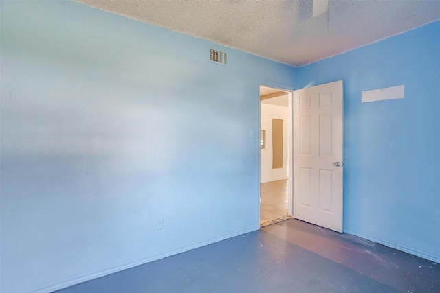 spare room with visible vents, a textured ceiling, and concrete flooring