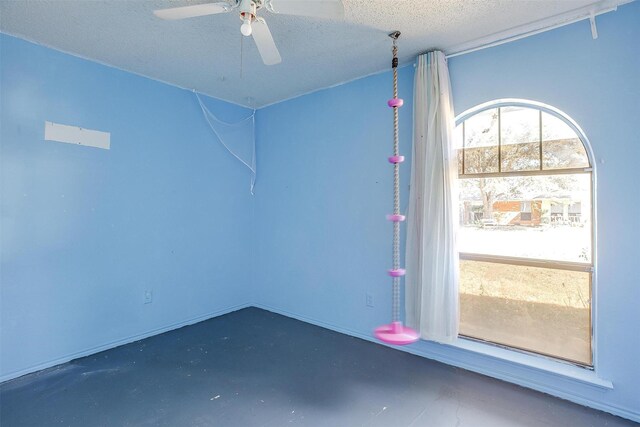 empty room featuring ceiling fan, finished concrete flooring, and a textured ceiling