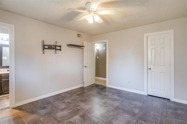 interior space with baseboards, visible vents, a textured ceiling, and a ceiling fan