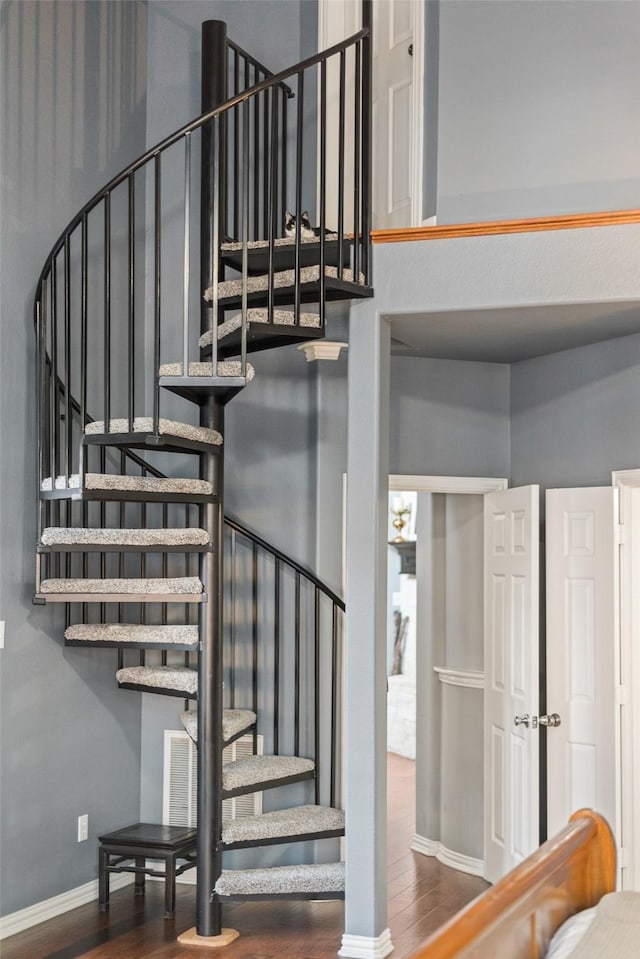 stairs featuring wood finished floors and baseboards