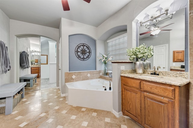 full bathroom featuring a garden tub, vanity, and ceiling fan