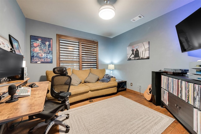 office featuring visible vents, baseboards, and wood finished floors