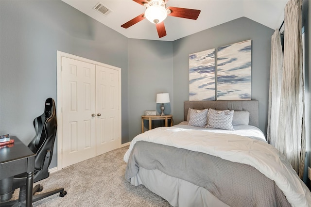 carpeted bedroom with visible vents, lofted ceiling, a closet, baseboards, and ceiling fan