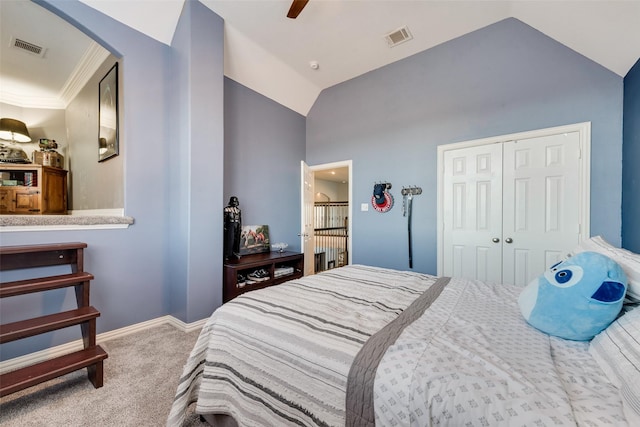 carpeted bedroom with baseboards, visible vents, lofted ceiling, and a closet