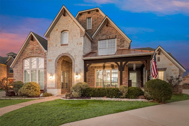 view of front of property with brick siding, stone siding, and a front lawn