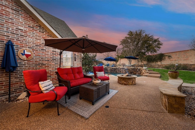 patio terrace at dusk featuring a fenced backyard and an outdoor hangout area