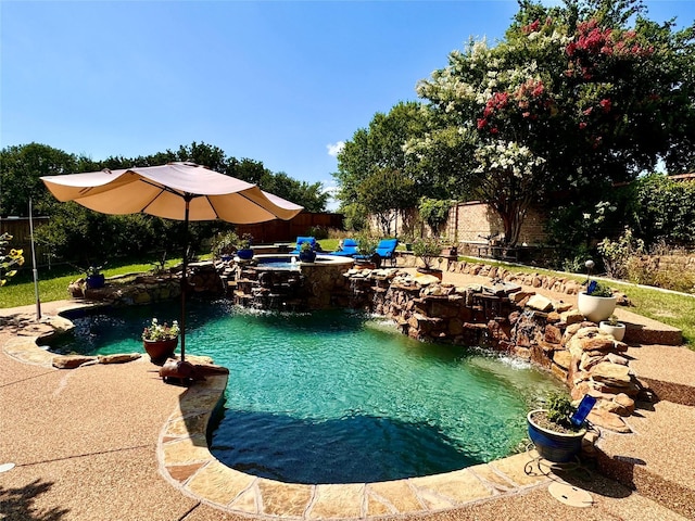 view of swimming pool featuring a fenced backyard and a pool with connected hot tub