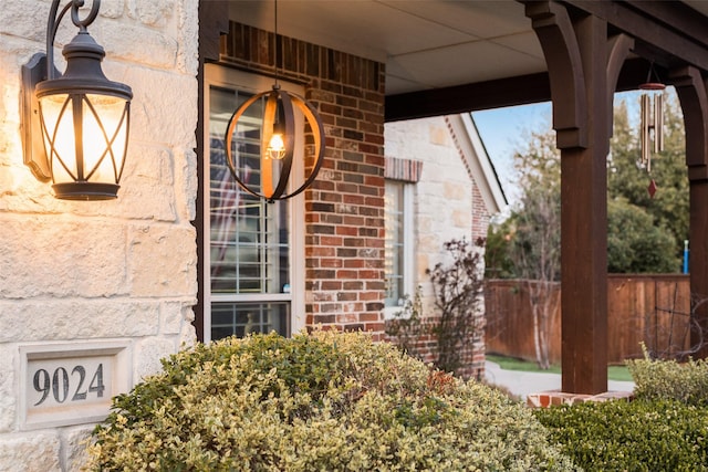 property entrance featuring brick siding and fence