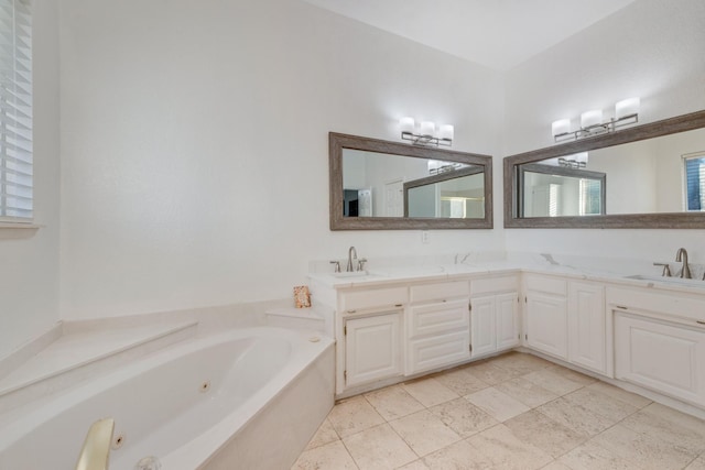 bathroom featuring a sink, double vanity, and a whirlpool tub