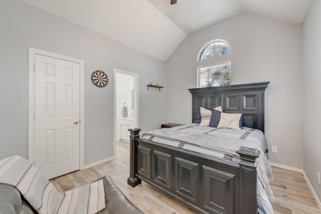 bedroom featuring vaulted ceiling, light wood-style flooring, baseboards, and connected bathroom