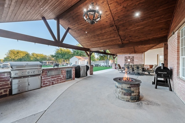 view of patio featuring a gazebo, area for grilling, an outdoor fire pit, and an outdoor kitchen