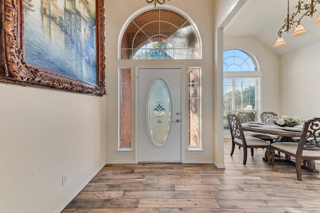 entrance foyer featuring baseboards, wood finished floors, and vaulted ceiling