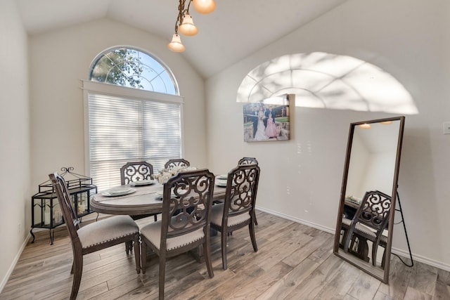 dining area featuring baseboards, lofted ceiling, and light wood-style floors