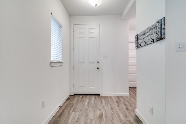 foyer entrance with baseboards and light wood finished floors