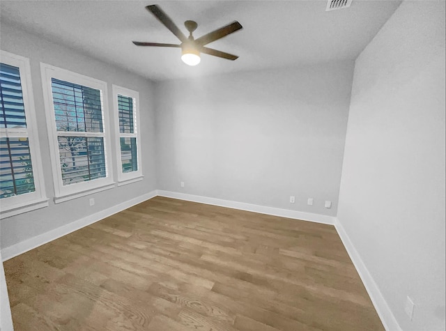 spare room with ceiling fan, baseboards, and wood finished floors